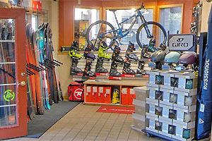 Store interior with racks of skis to the left and ski boots straight ahead