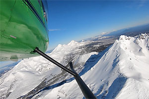 Helicopter overlooking snow-covered mountains.