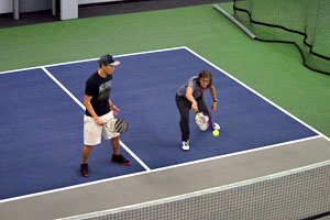 Pickleball court with two students receiving private instruction.