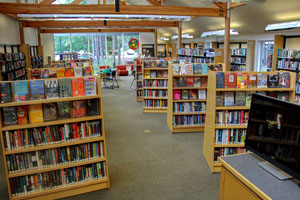 Library interior with shelves of books and a seating area in the background.