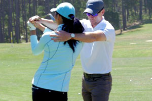 Instructor assisting a woman with her swing.