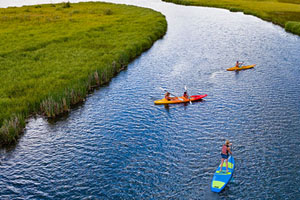Two kayaks and a stand up paddle board in the Sunriver Marina inlet.