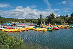 Sunriver Marina dock with canoes and multi-colored kayaks.