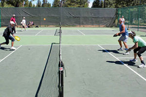 Sunriver pickleball courts with four players engaged in a game of doubles.