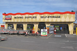 Utility trailers in a row to the left with storefront and store entrance in the background.